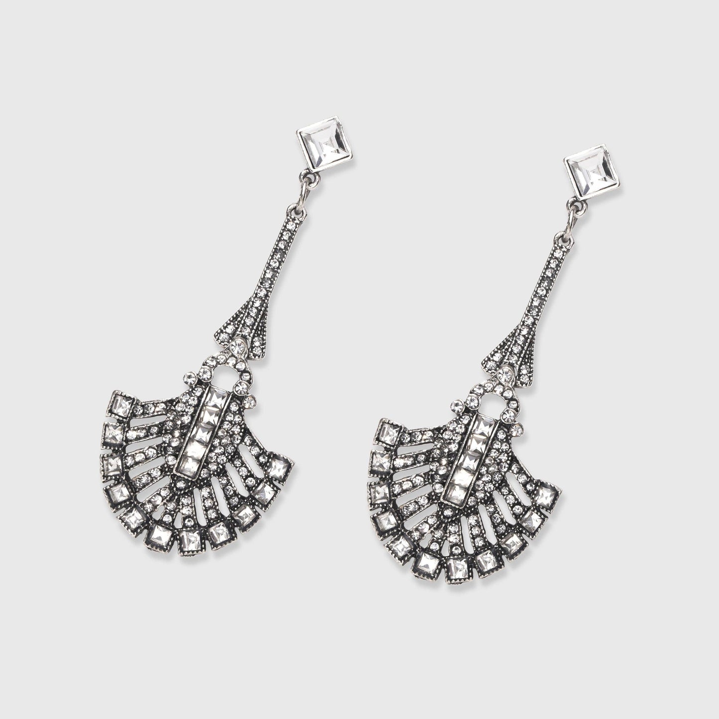 Pair of silver fan-shaped earrings on a light gray background