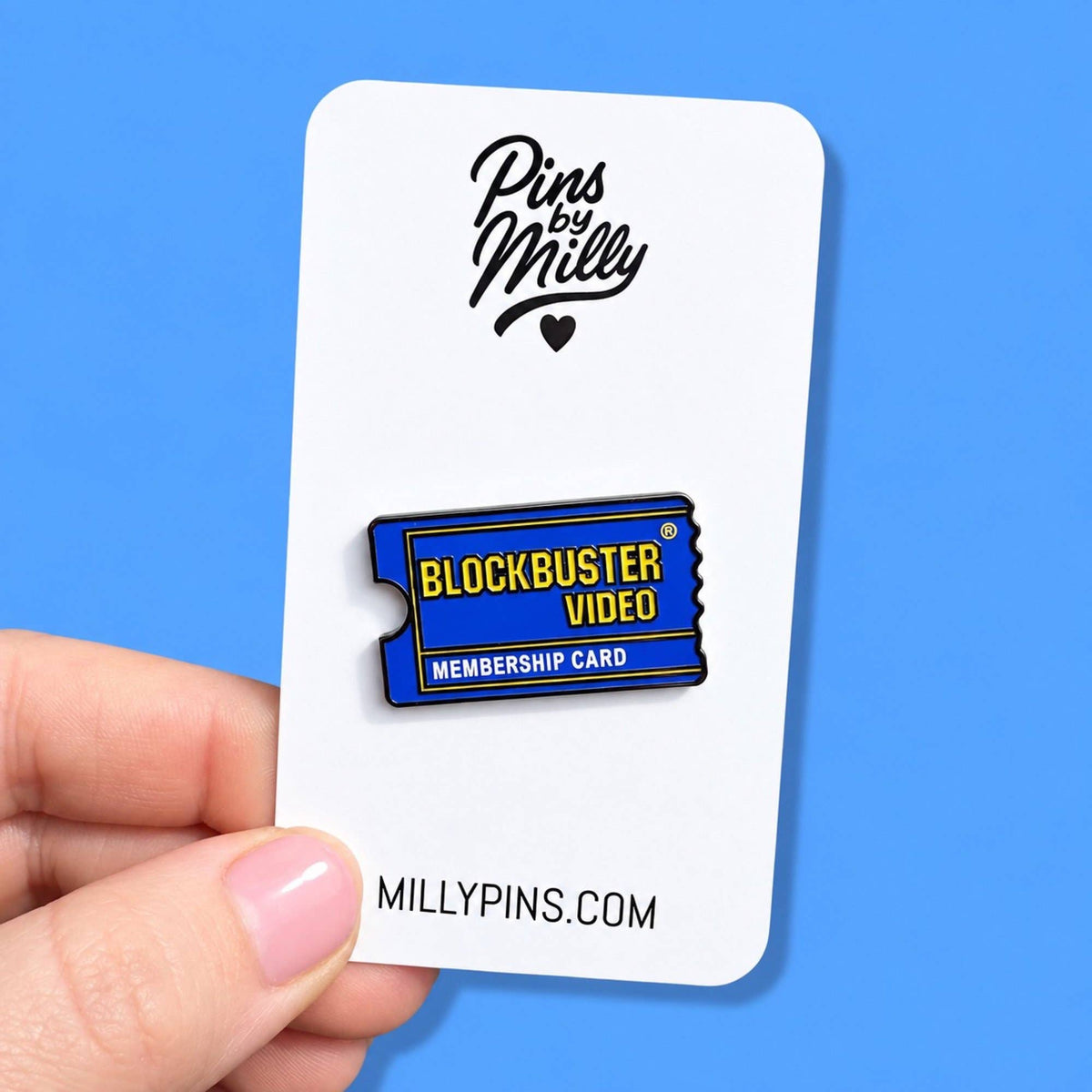 Featuring an enamel pin shaped like a movie ticket. The pin is blue with yellow and white text reading 'BLOCKBUSTER VIDEO' and 'MEMBERSHIP CARD.