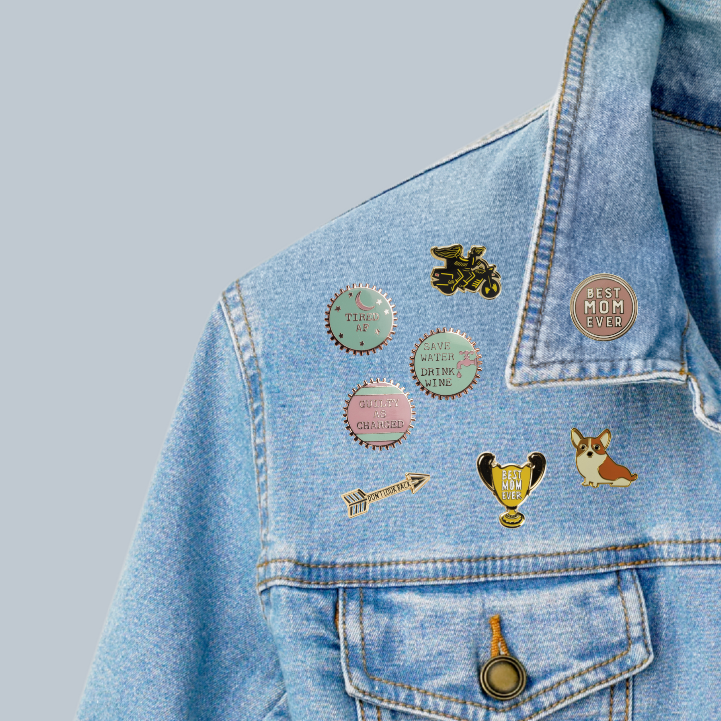 A variety of enamel pins on a jean jacket