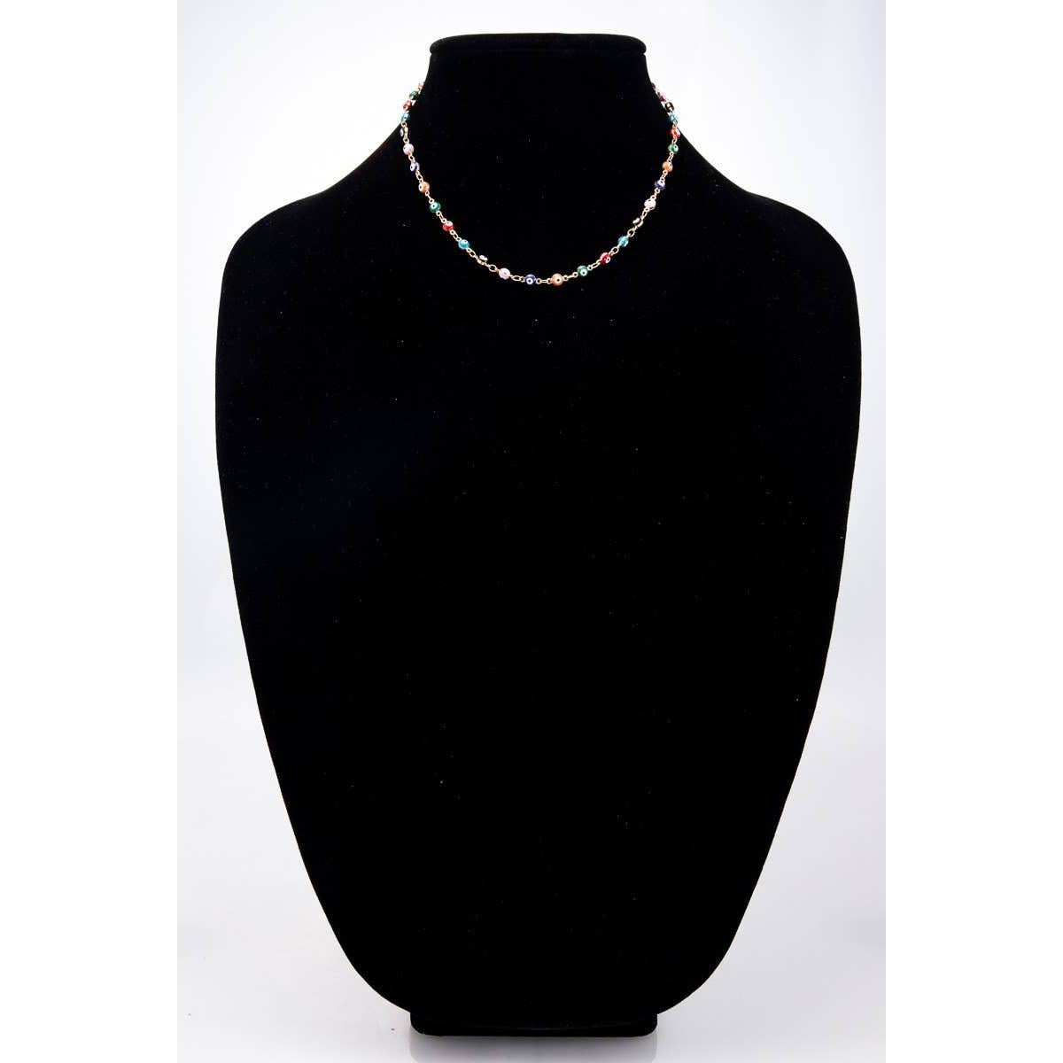 Necklace on a black mannequin bust against a white background