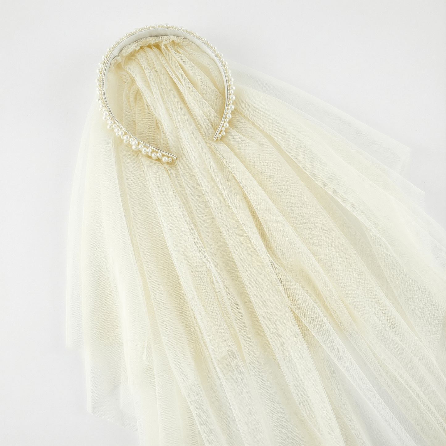White tulle veil with a decorative headband on a white background
