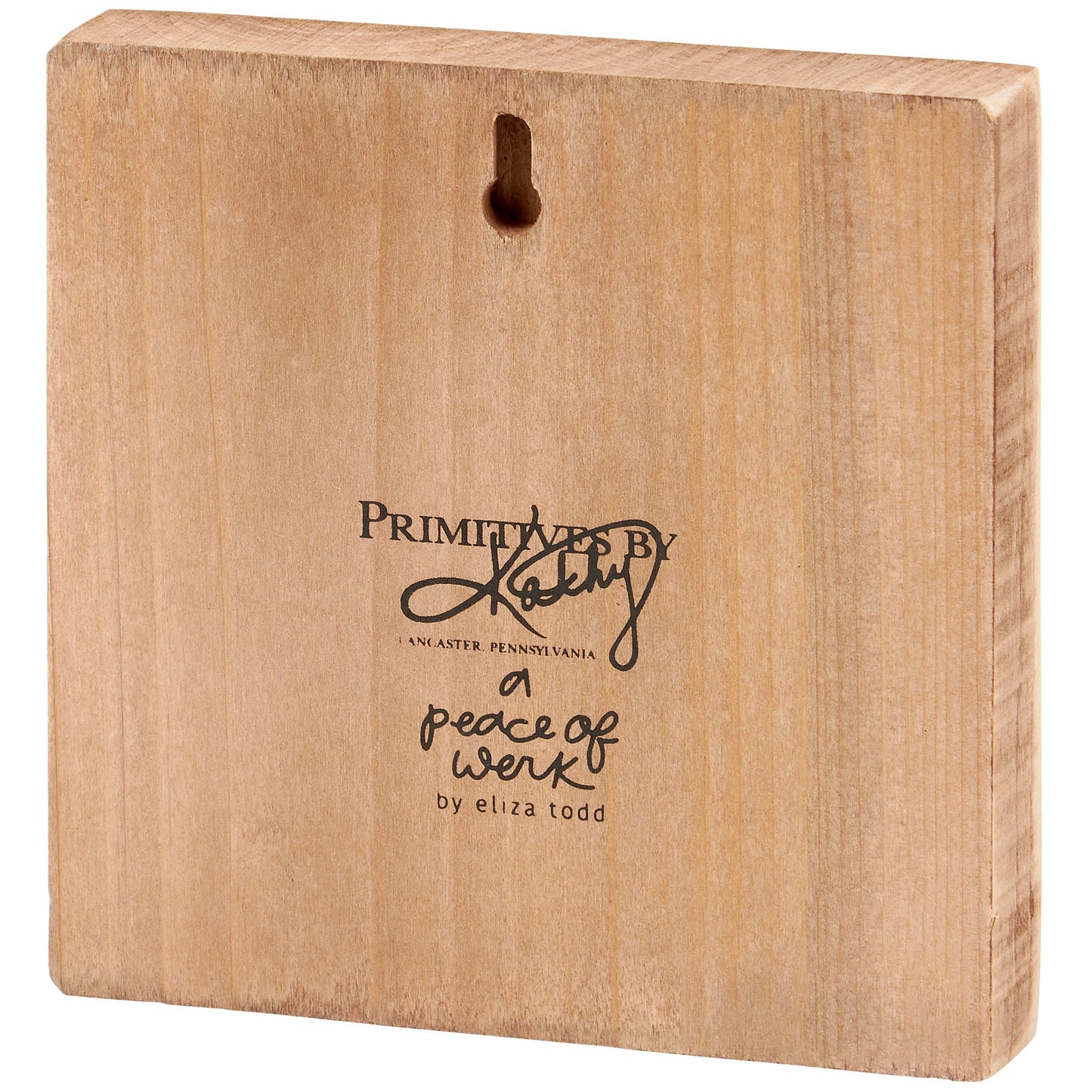 Wooden block with 'Primitive by Kathy' branding and text on a white background
