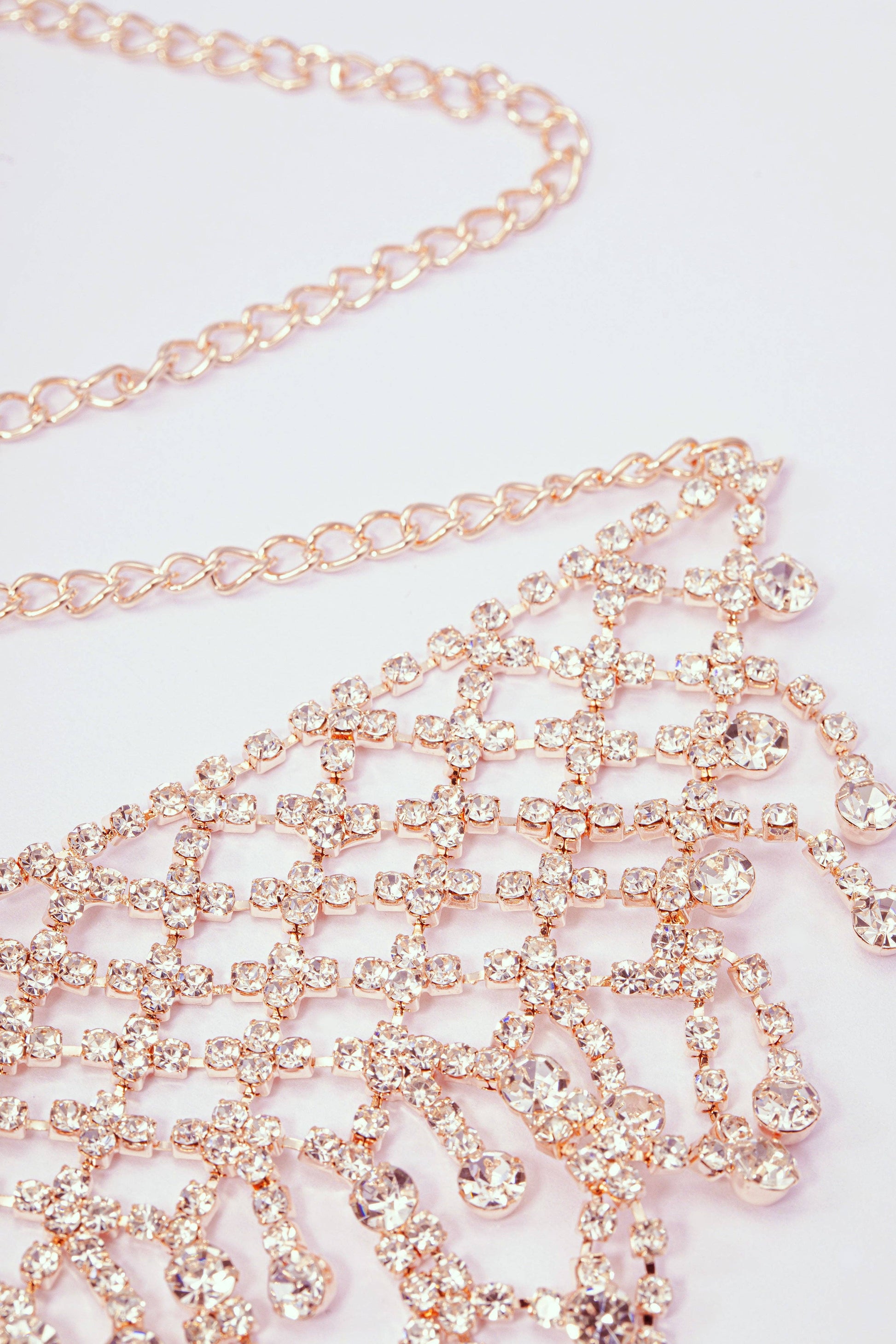 Rose gold chain with crystals on a light pink background