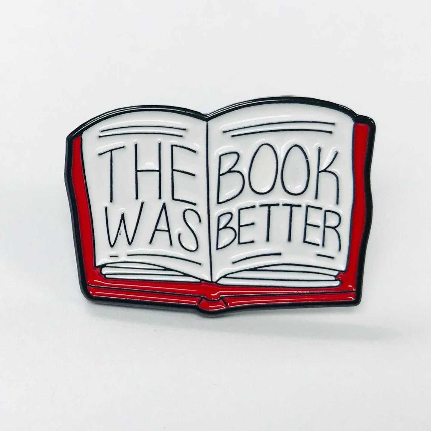 Enamel pin shaped like an open book with 'The Book Was Better' text 