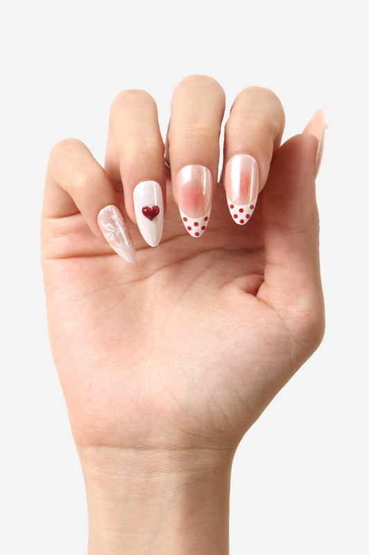 Hand with painted nails featuring heart and polka dot designs