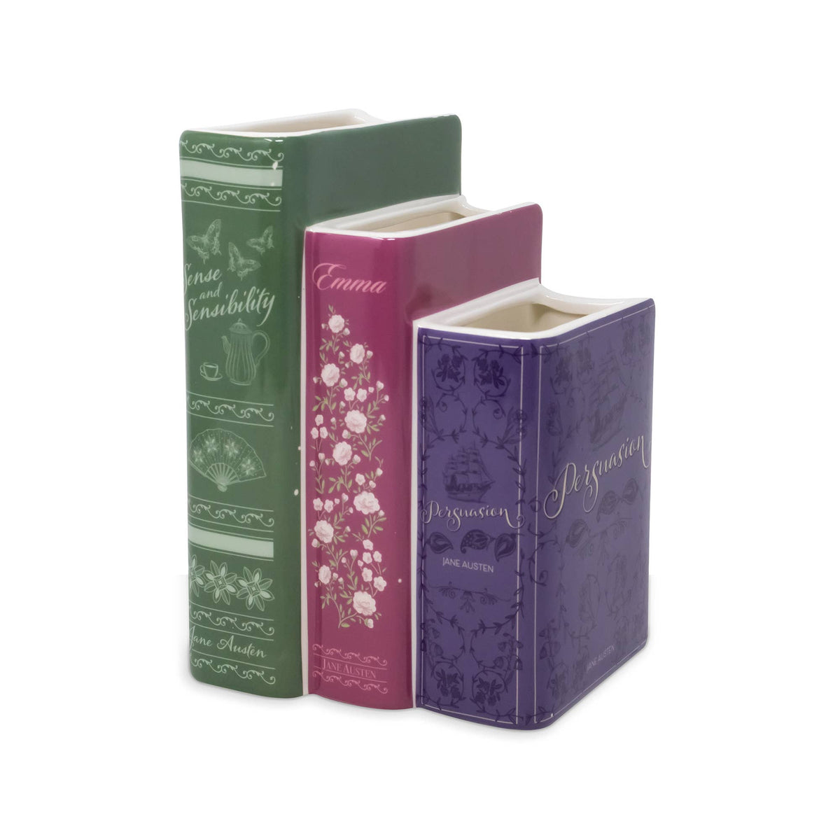 Three decorative book-shaped flower vase standing upright on a white background, colored green, pink, and purple with floral and ornamental printed details.