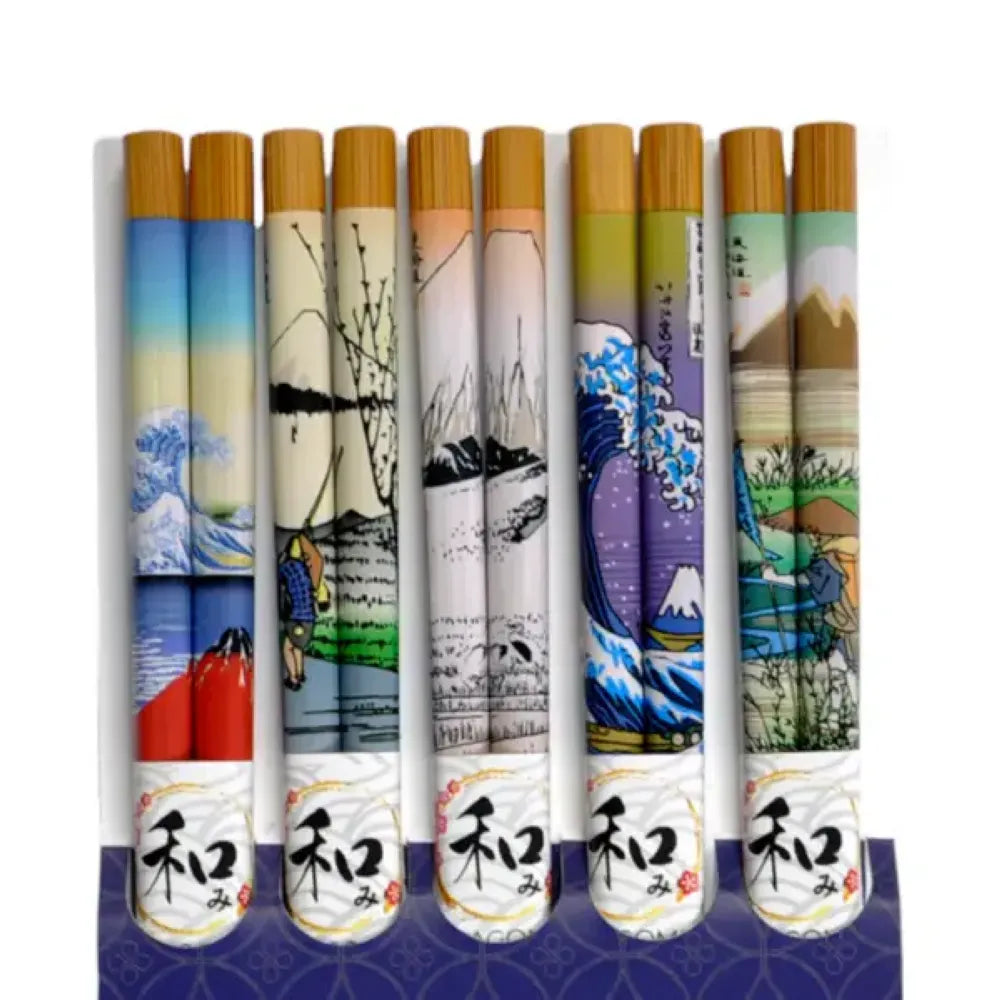 5 pairs of decorative chopsticks standing upright in a row, each with a bamboo-look top, a printed scenic illustration on the body, and a white lower section with black Japanese characters. The illustrations include blue waves, mountains, trees, and landscapes.