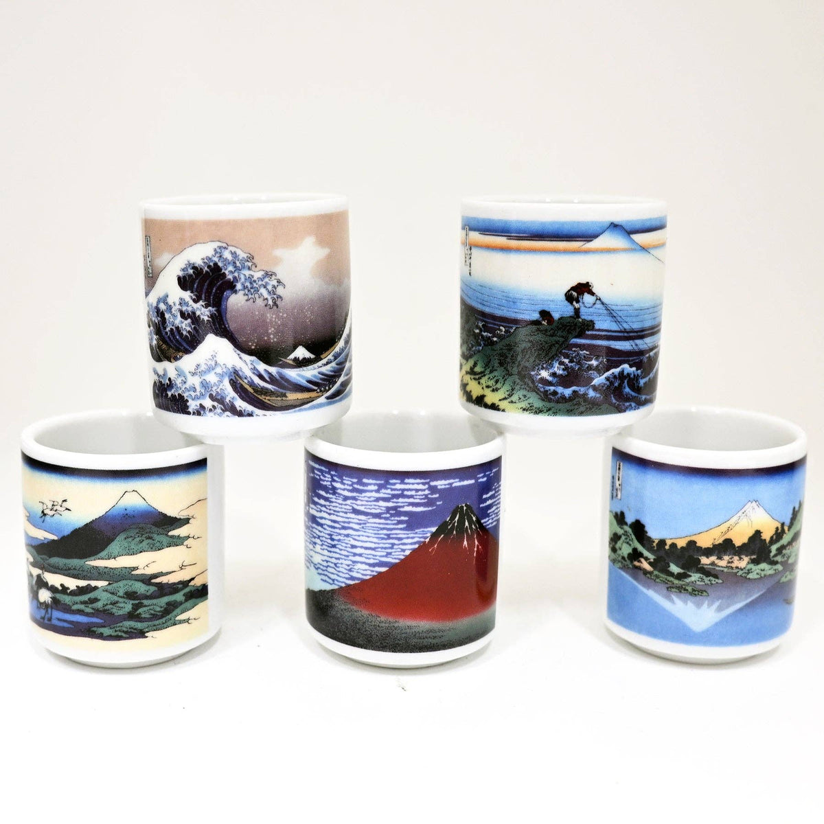 Five ceramic mugs with artistic designs of landscapes