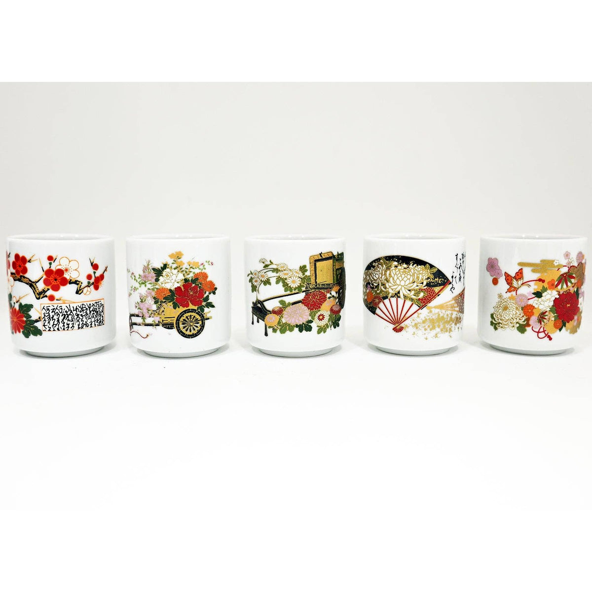 Five white ceramic cups lined up in a row, each decorated with different Japanese-style floral and traditional illustrations in red, gold, green, and black.