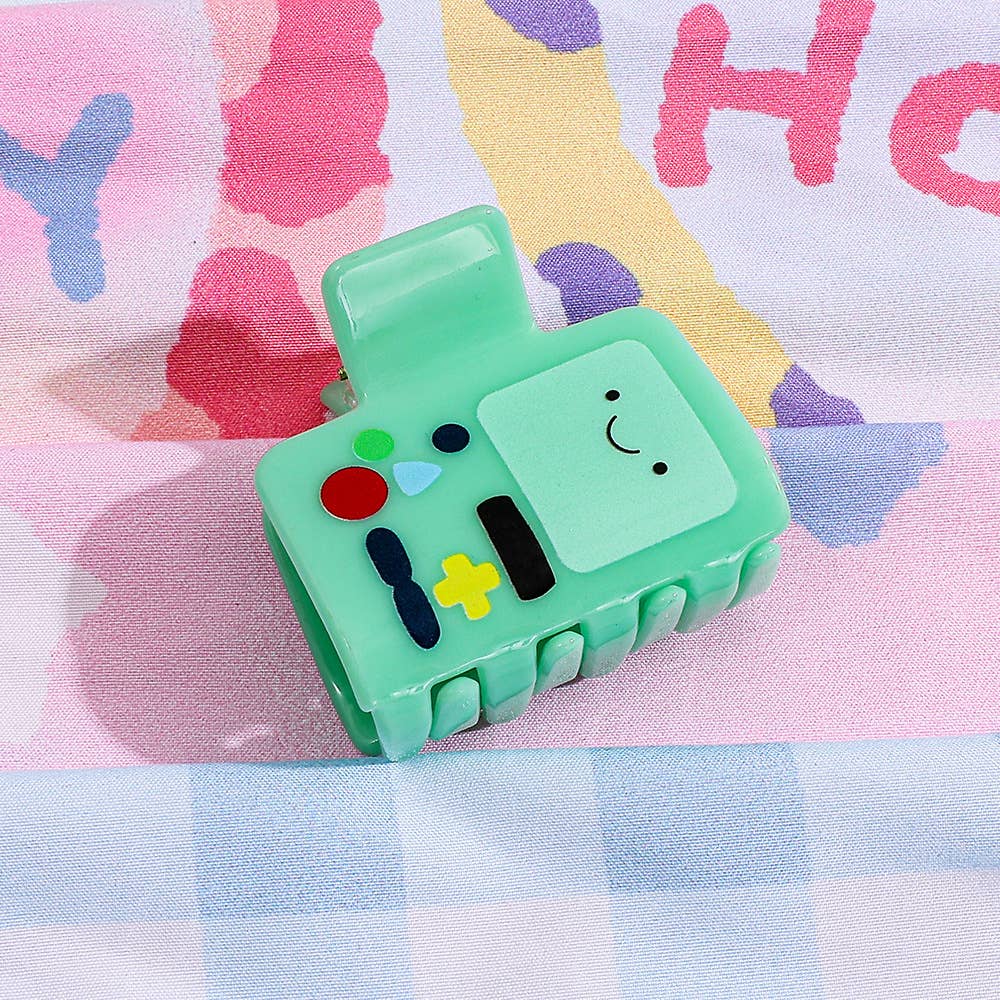 Green character-shaped hair claw on a colorful background