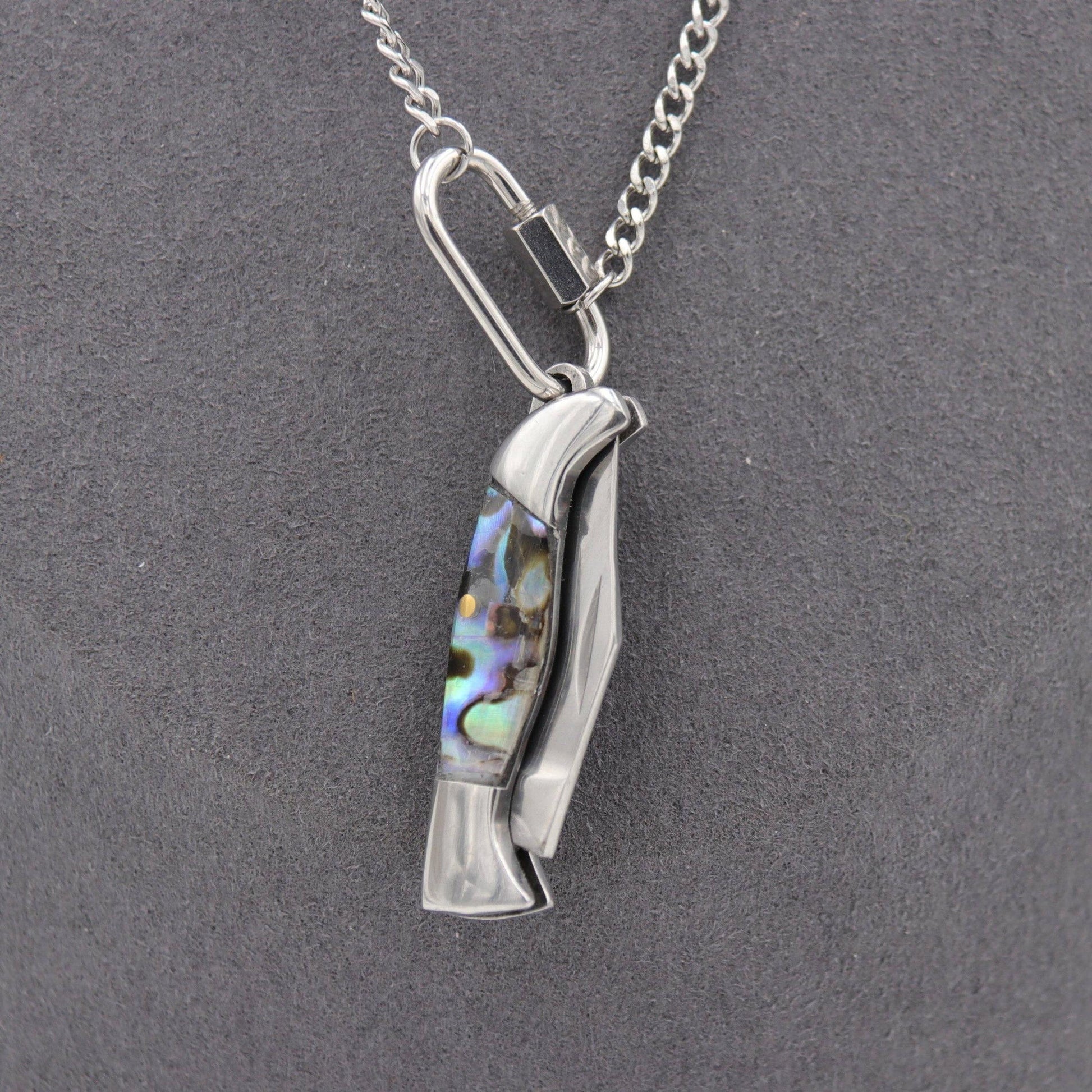 Silver pendant with abalone shell inlay on a gray background