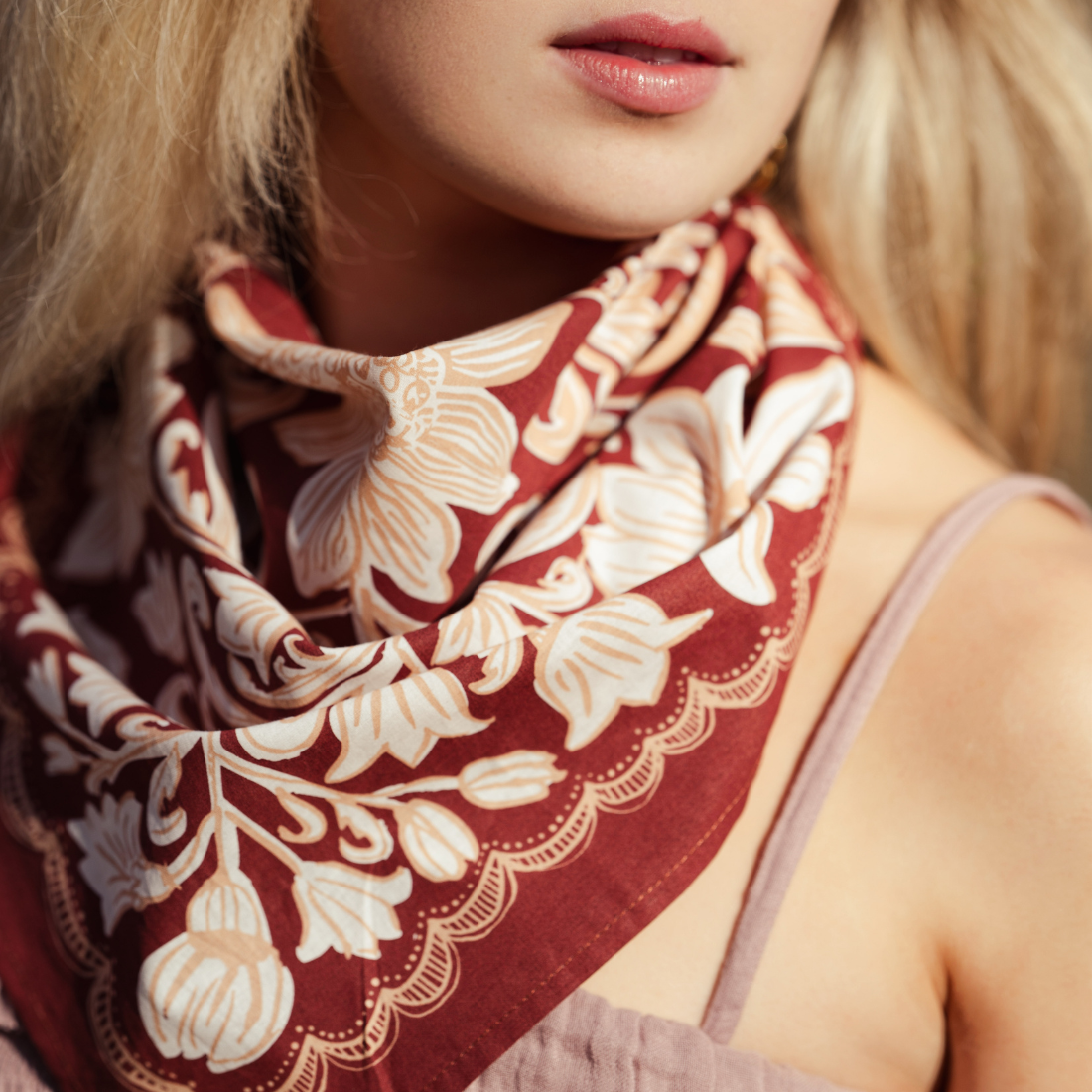 Close-up of a woman wearing a floral patterned scarf with a blurred background