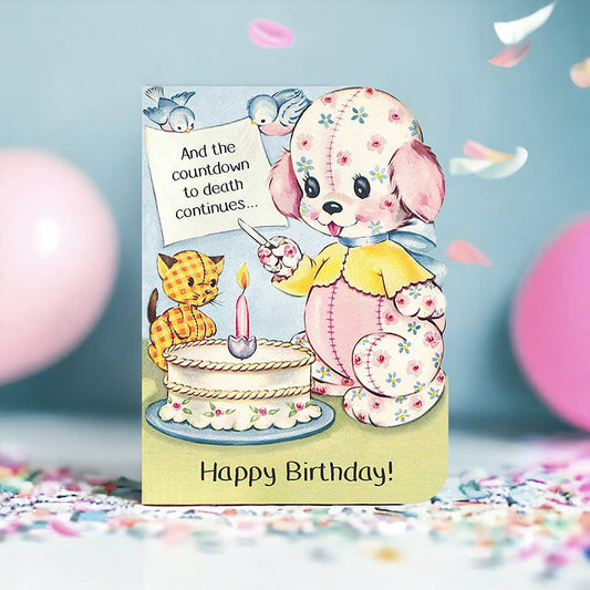 Birthday card with cartoon dog and cat by a cake, surrounded by balloons and confetti.
