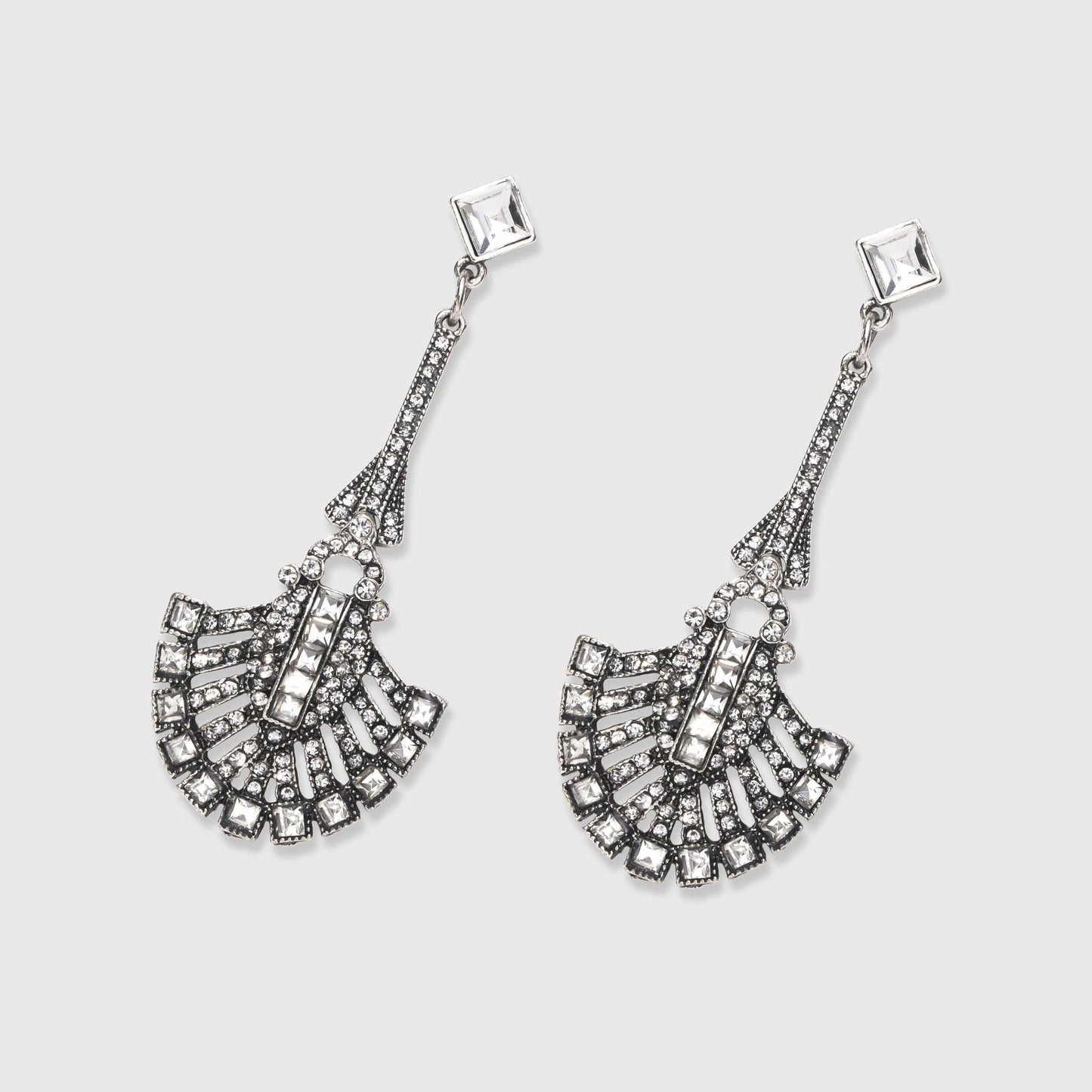 Pair of silver fan-shaped earrings on a light gray background