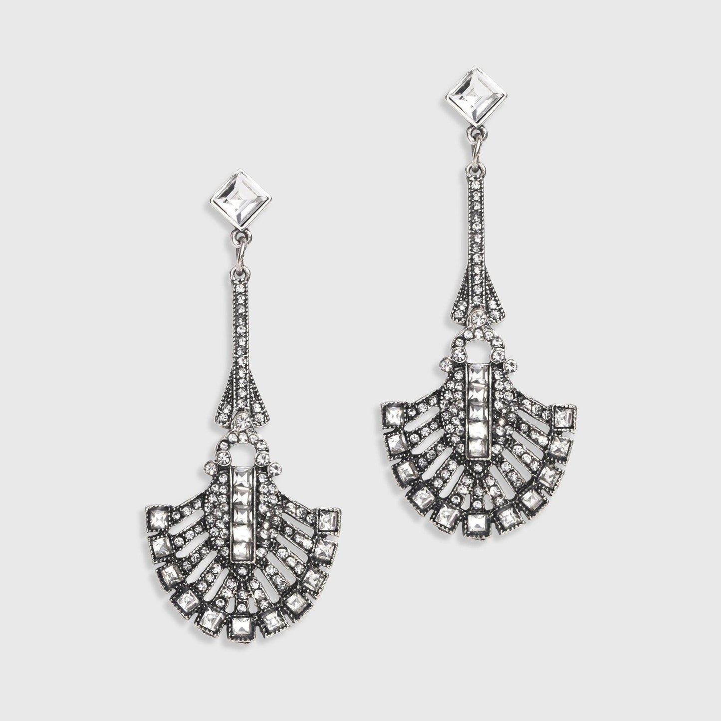Pair of silver earrings with intricate designs on a light gray background