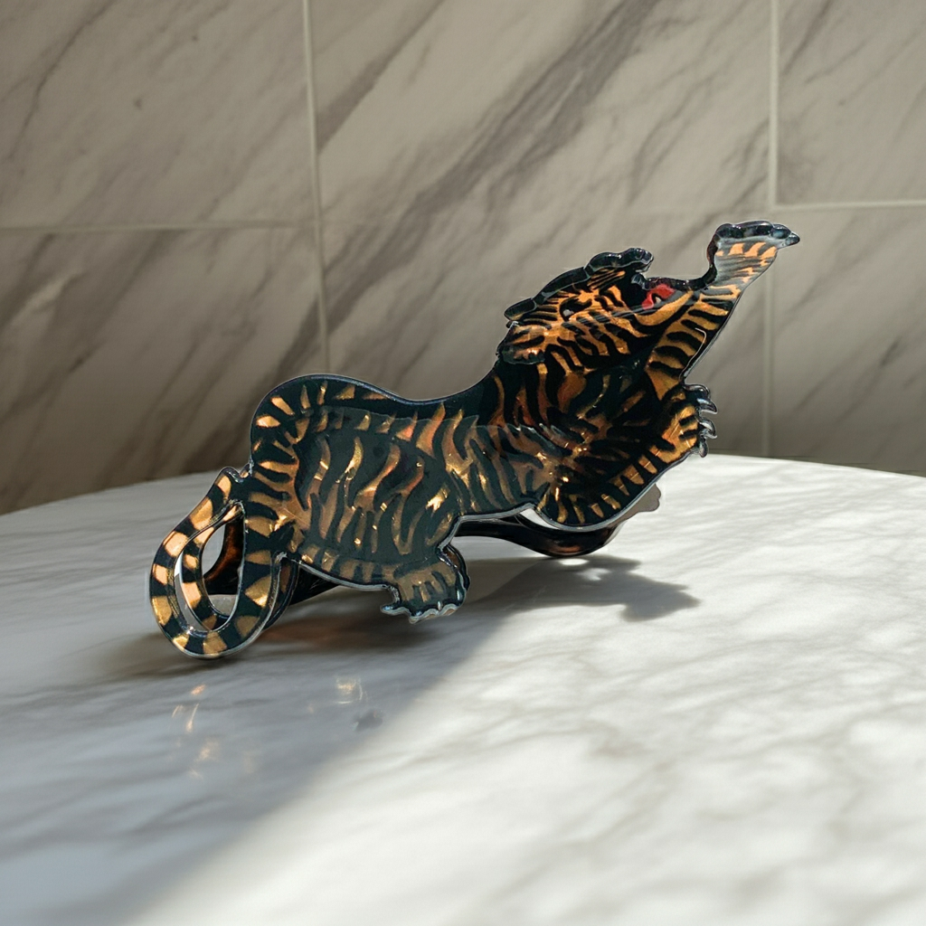 Metallic tiger figurine on a marble surface with a neutral background
