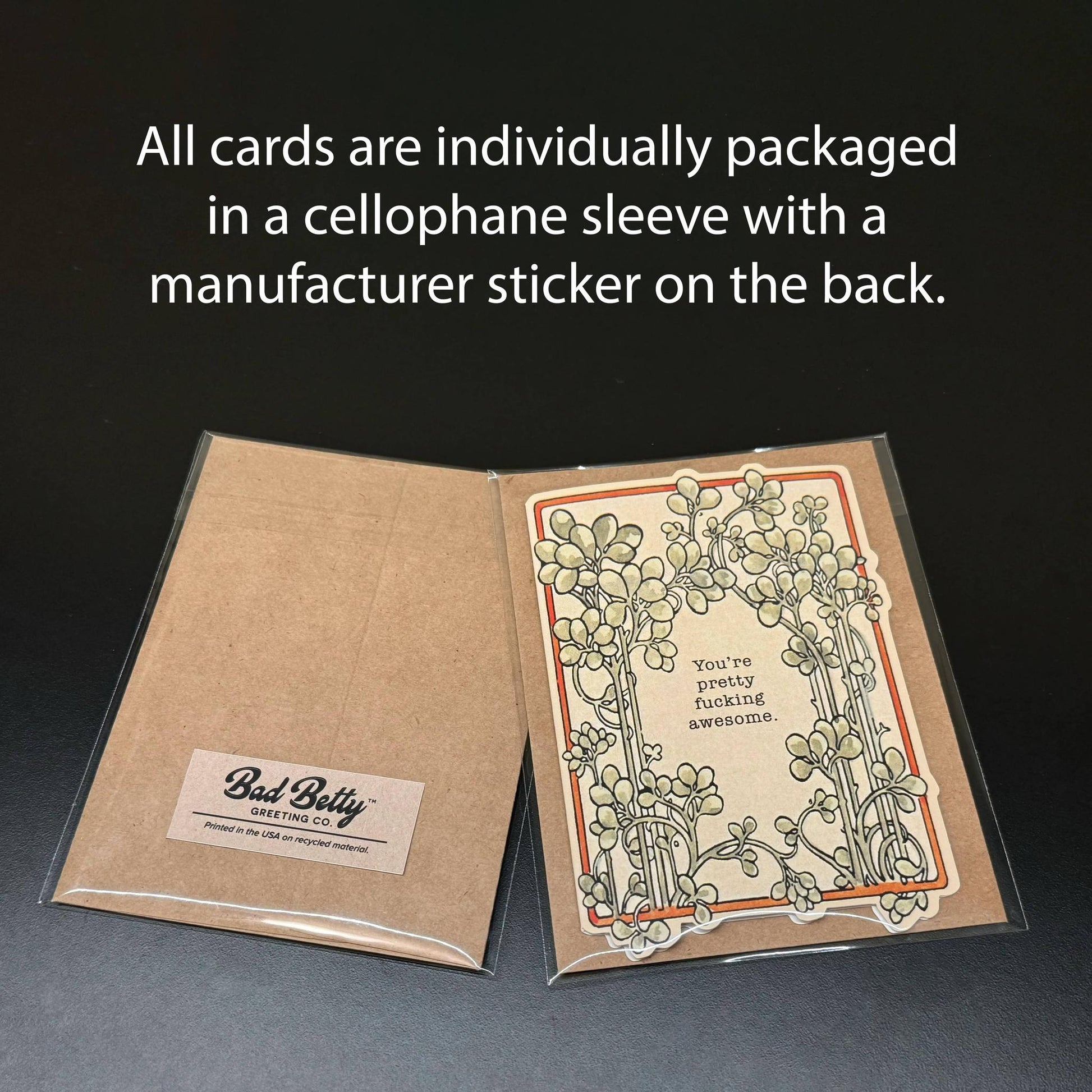 Card packaging with cellophane sleeve and Bad Betty logo on a dark background