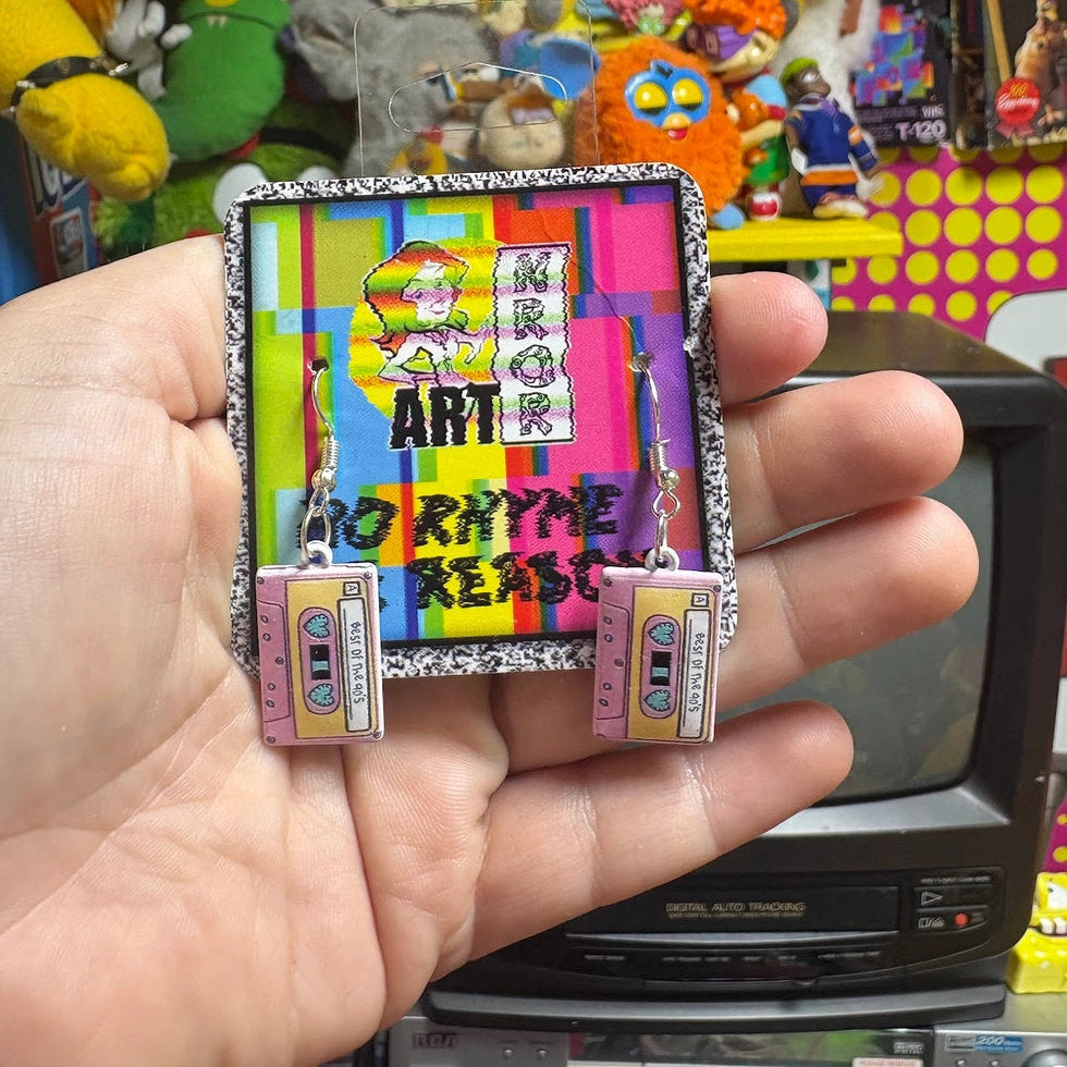 Colorful art-style cassette tape earrings held by a hand