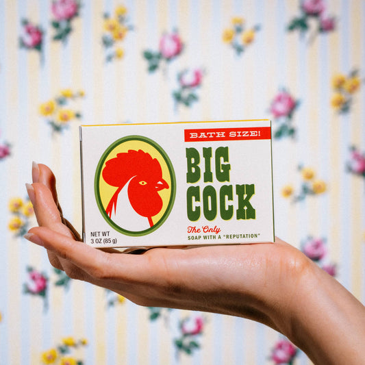 Hand holding a box of Big Cock soap 