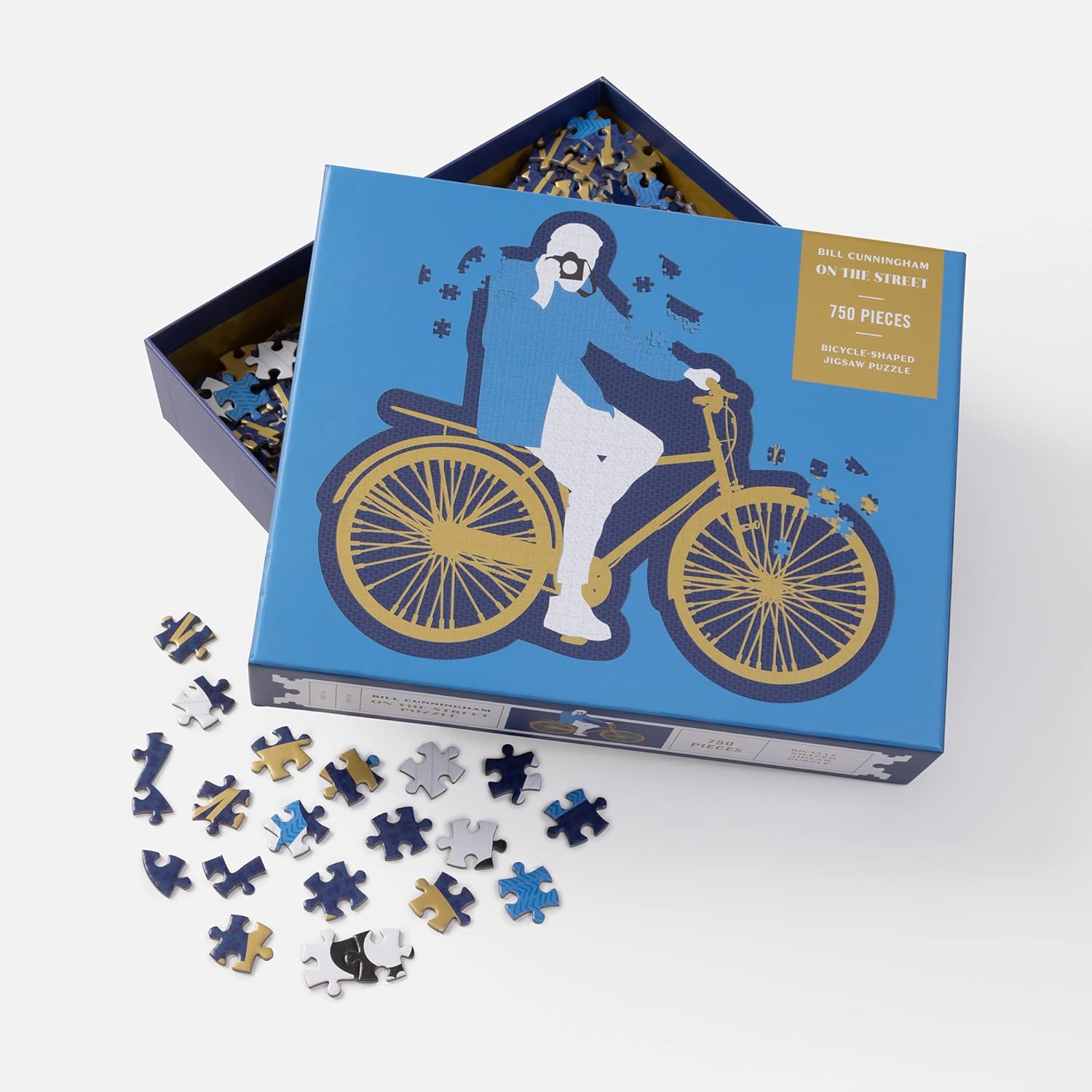 Jigsaw puzzle with pieces scattered, featuring a design of a person on a bicycle, in a blue box.
