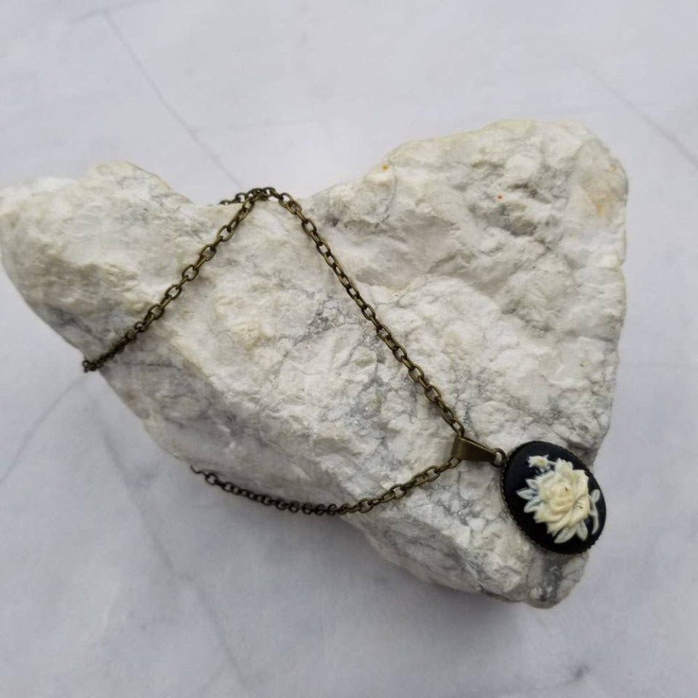 Necklace with a floral pendant on a textured stone surface
