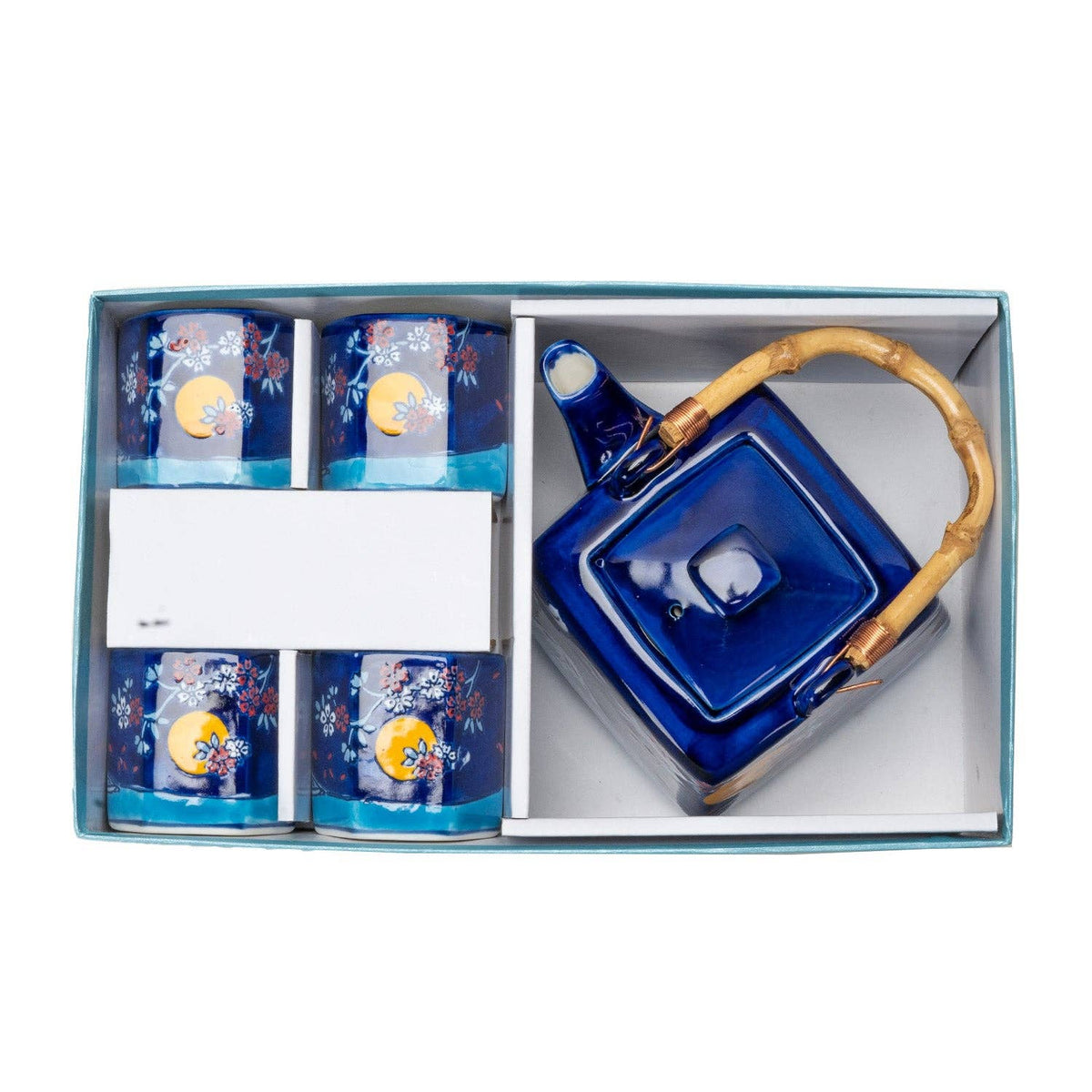 A boxed ceramic tea set set including a blue teapot with a bamboo handle and four matching blue cups with floral and moon designs, presented in a light blue gift box.