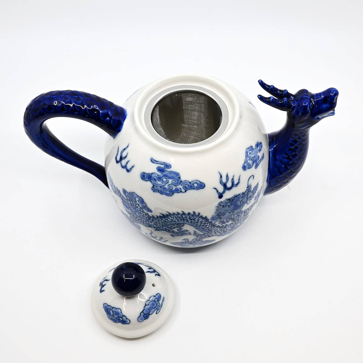 Ceramic teapot with blue dragon design on a white background