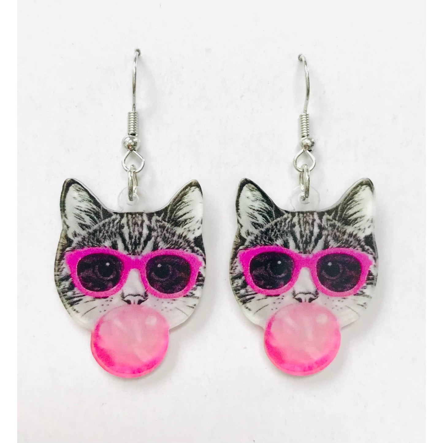 Cat-shaped earrings with pink sunglasses and pink beads on a white background