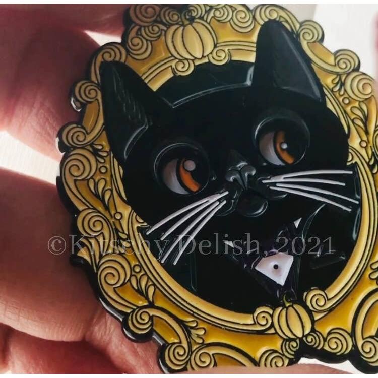 Black cat pin design on a decorative yellow background