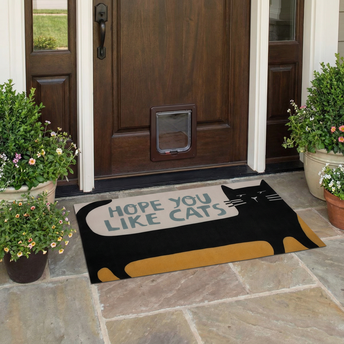 Doormat with cat design and text 'Hope you like cats' in front of a wooden door.