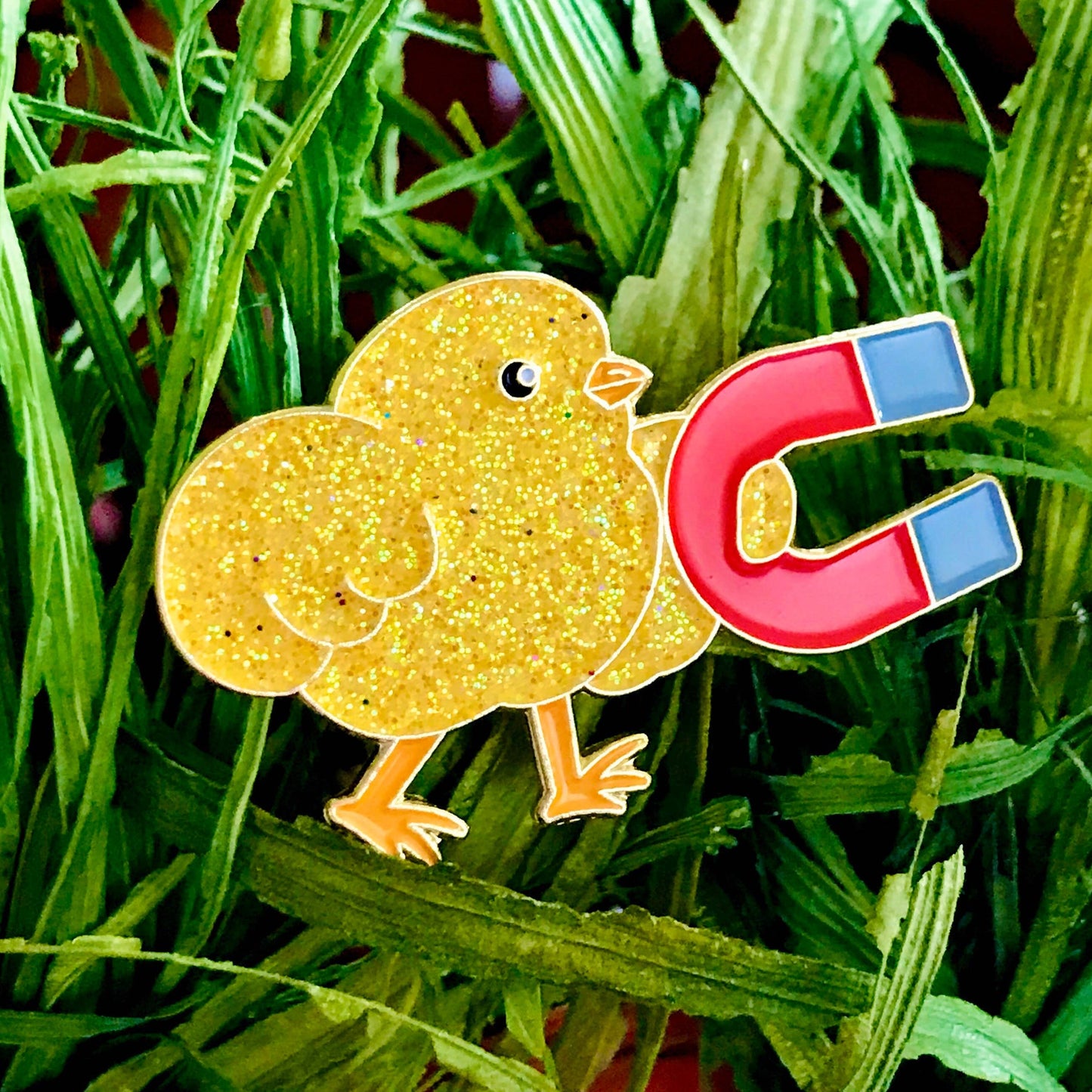 Cartoon chick with a magnet lapel pin on grass