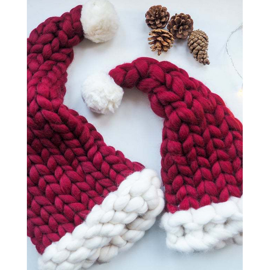Two red and white knitted hats with pom-poms on a light background.