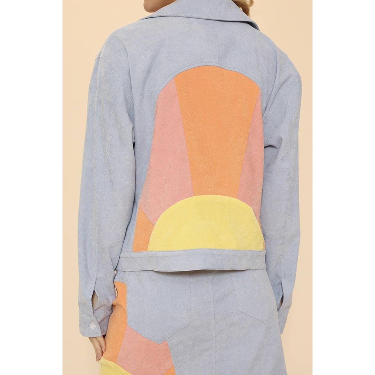 Light blue denim jacket with colorful geometric pattern on a beige background