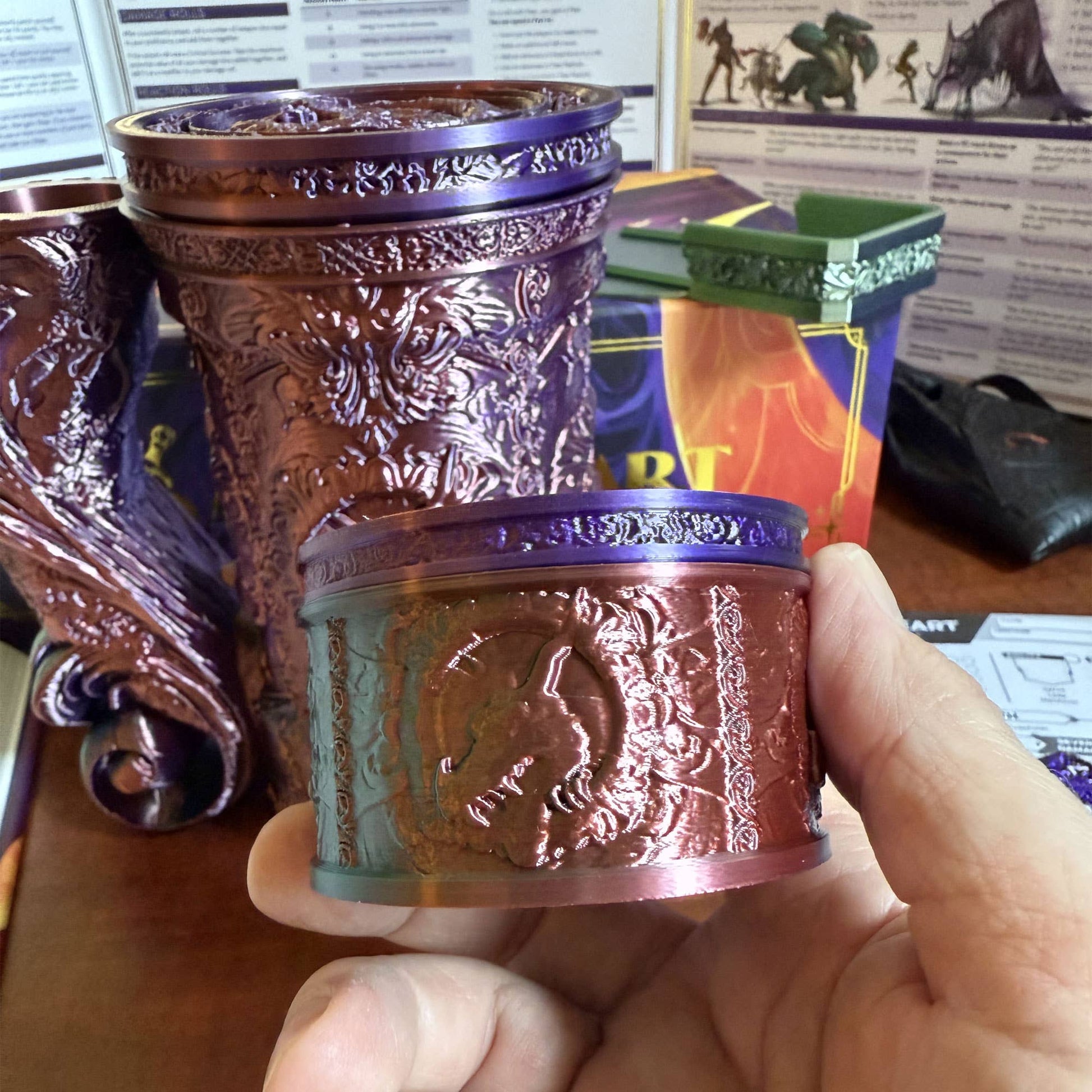 Decorative purple and gold container held by a hand with a blurred background