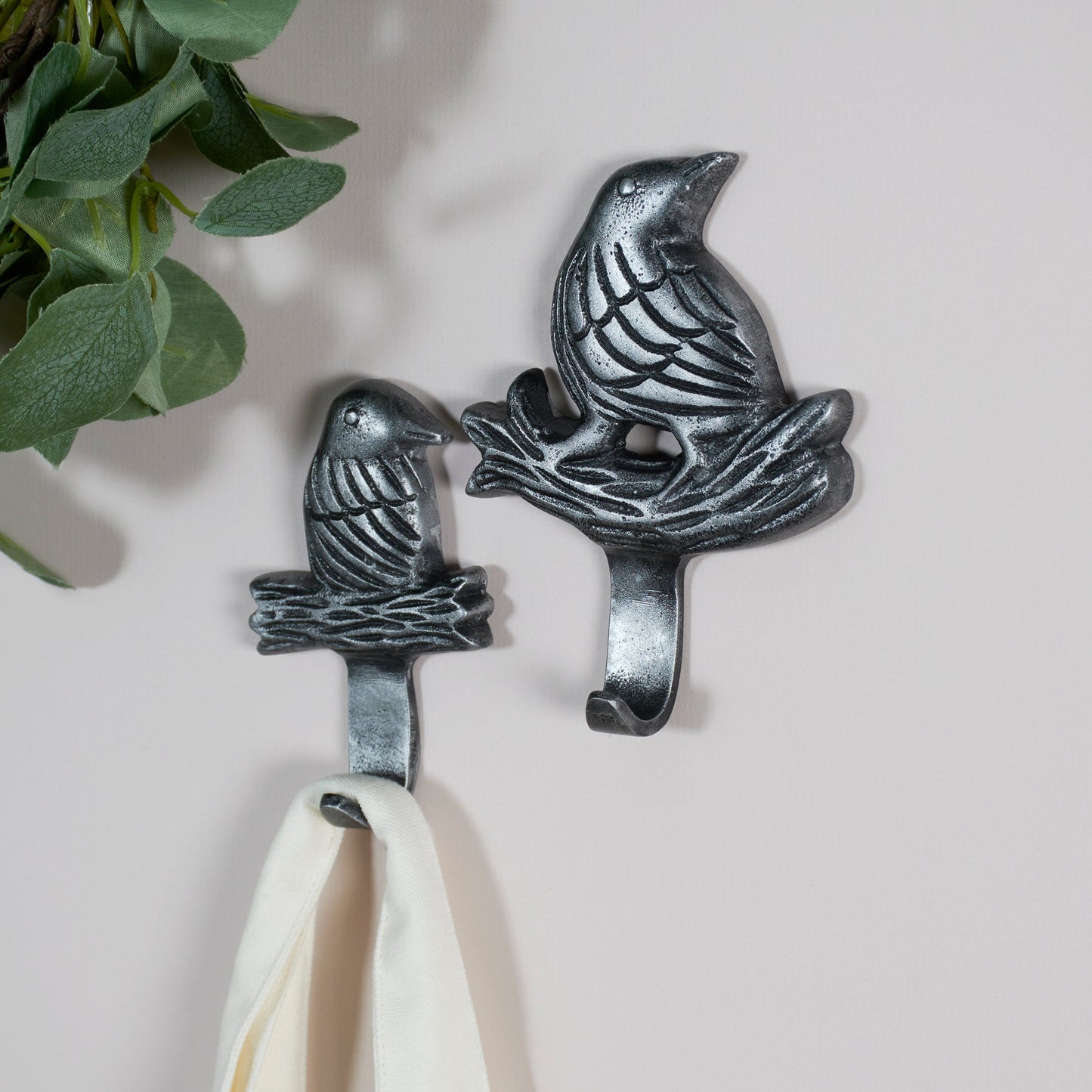 Decorative metal wall hooks shaped like birds on a white background