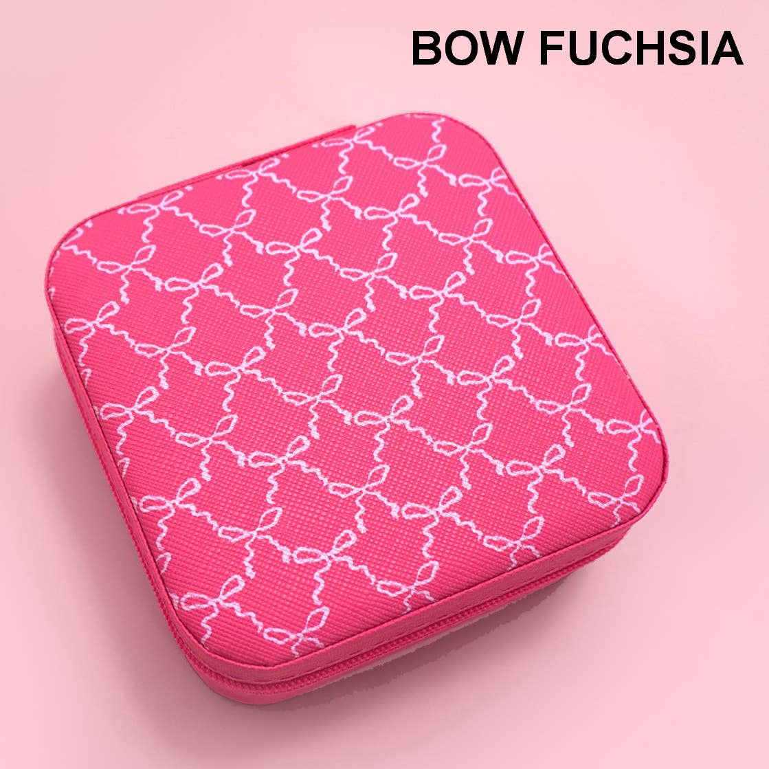 A fuchsia pink zippered case with a white bow pattern