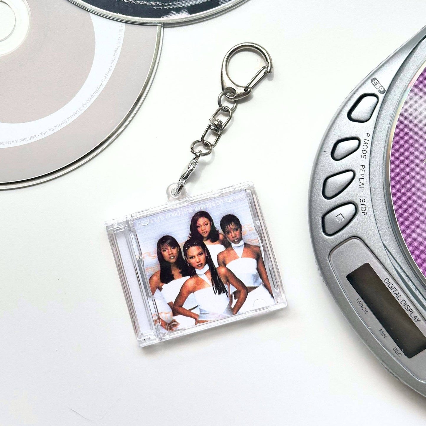 A clear acrylic CD-style keychain featuring a printed photo of the group Destiny's Child