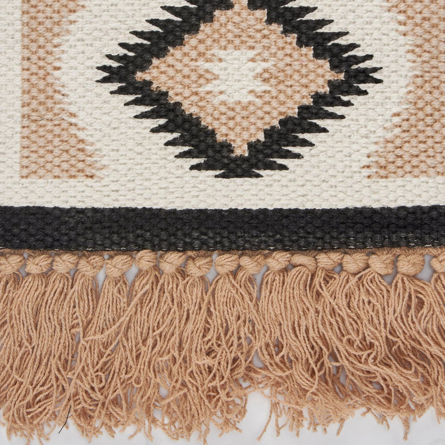 Close-up of a woven decor with geometric pattern and fringes 