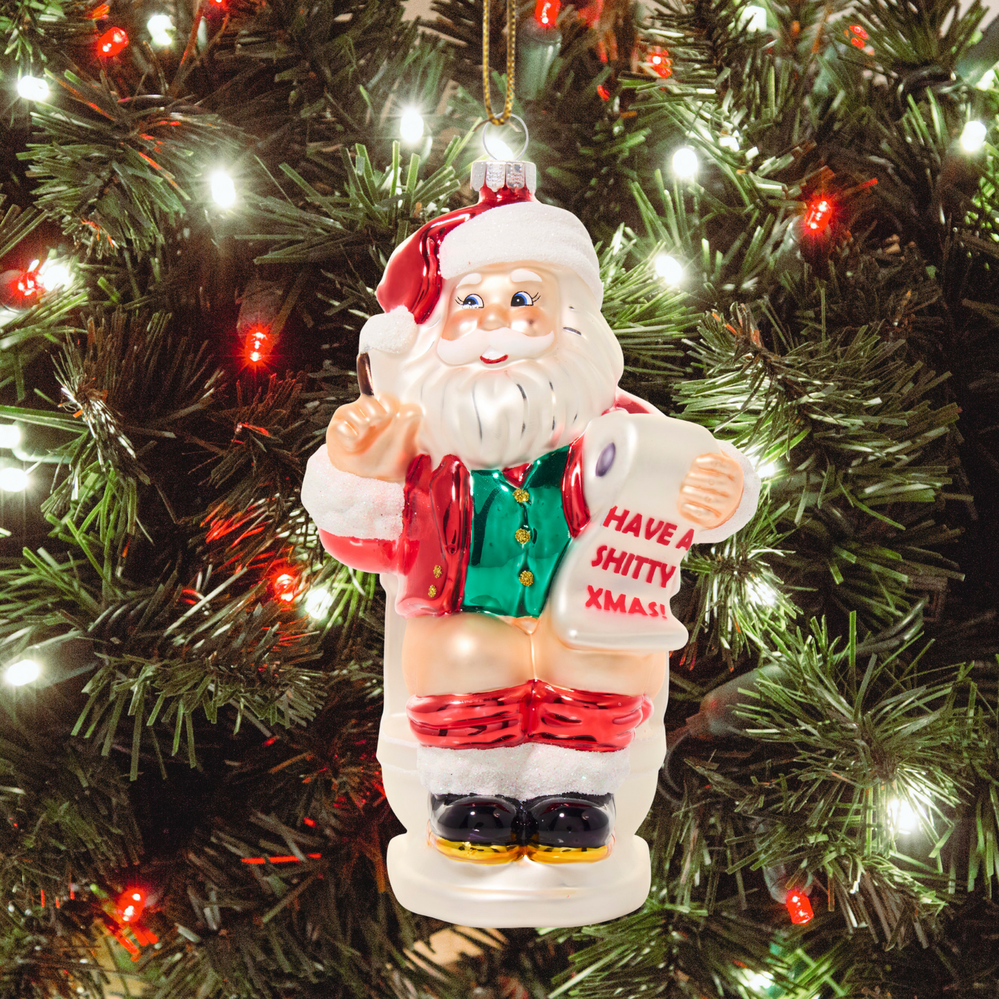 Santa Claus ornament with a humorous message on a Christmas tree.