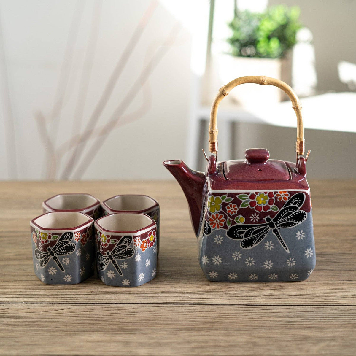 Ceramic teapot and four cups with floral and dragonfly designs 