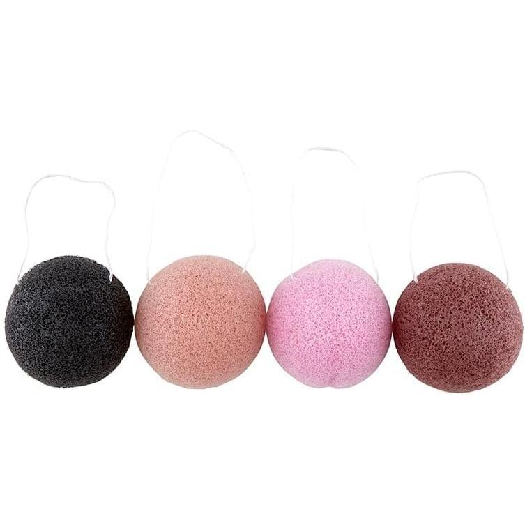 Set of four different colored makeup sponges on a white background