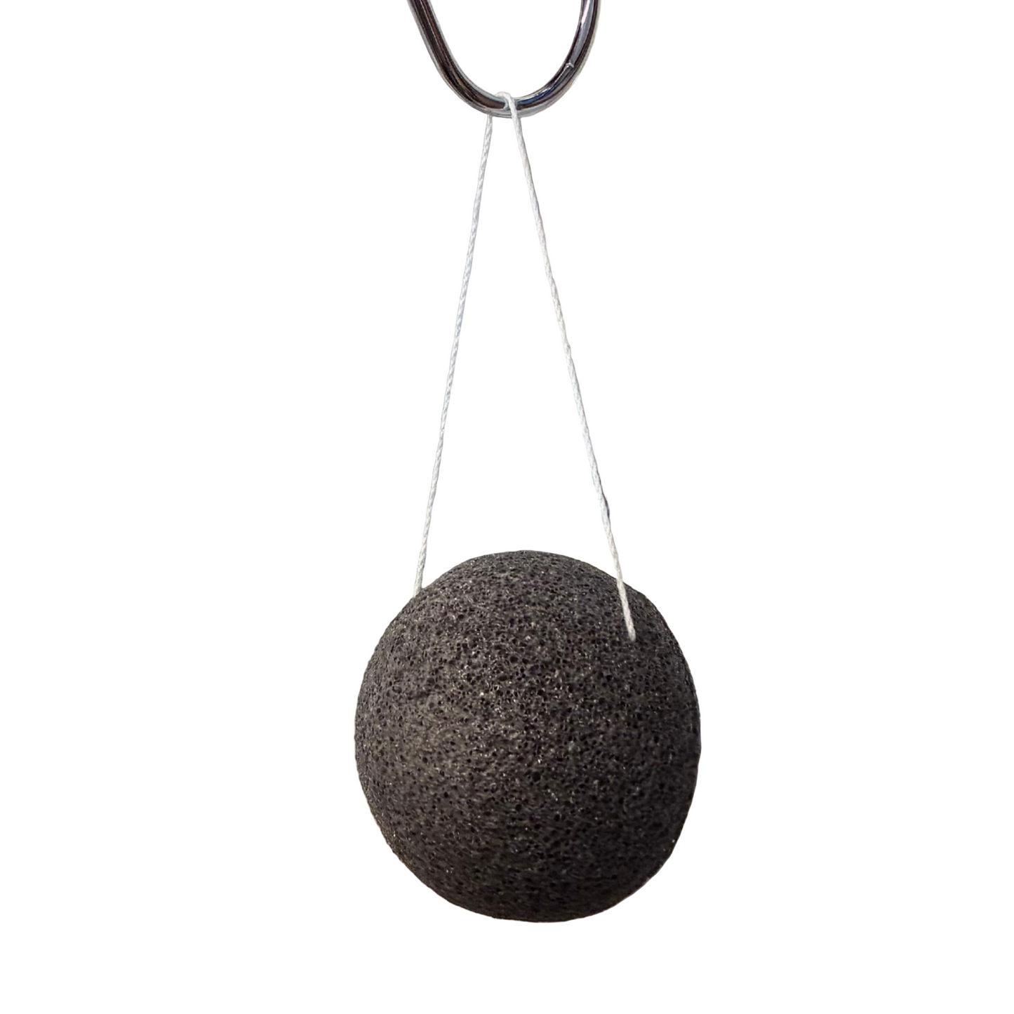 Black spherical sponge hanging from a string on a white background