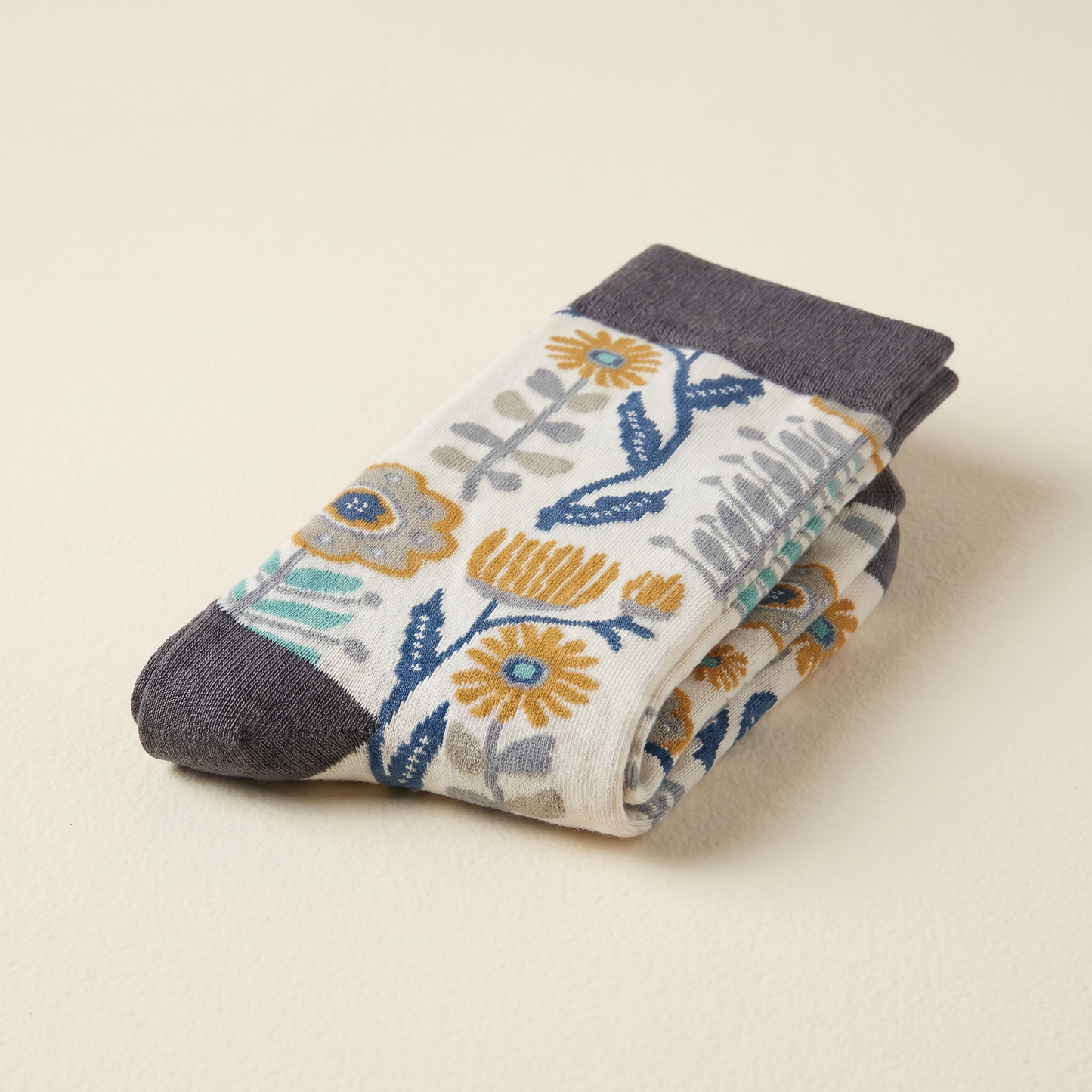 Floral-patterned sock with gray cuffs and toes on a beige background