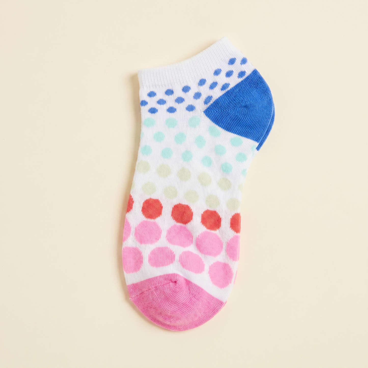 Colorful polka dot sock on a beige background