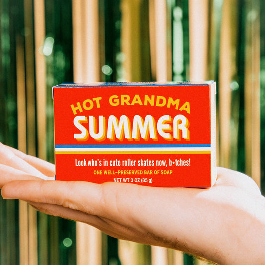 Hand holding a box of 'Hot Grandma Summer' soap 