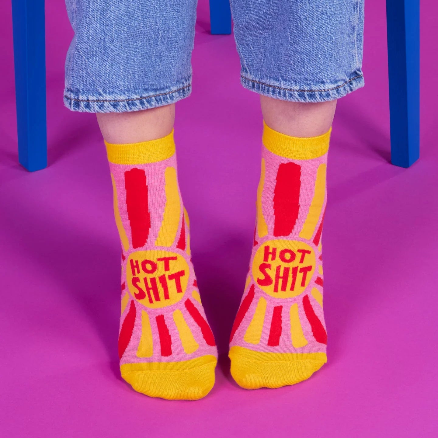 Person wearing socks with 'Hot Shit' text on a purple background