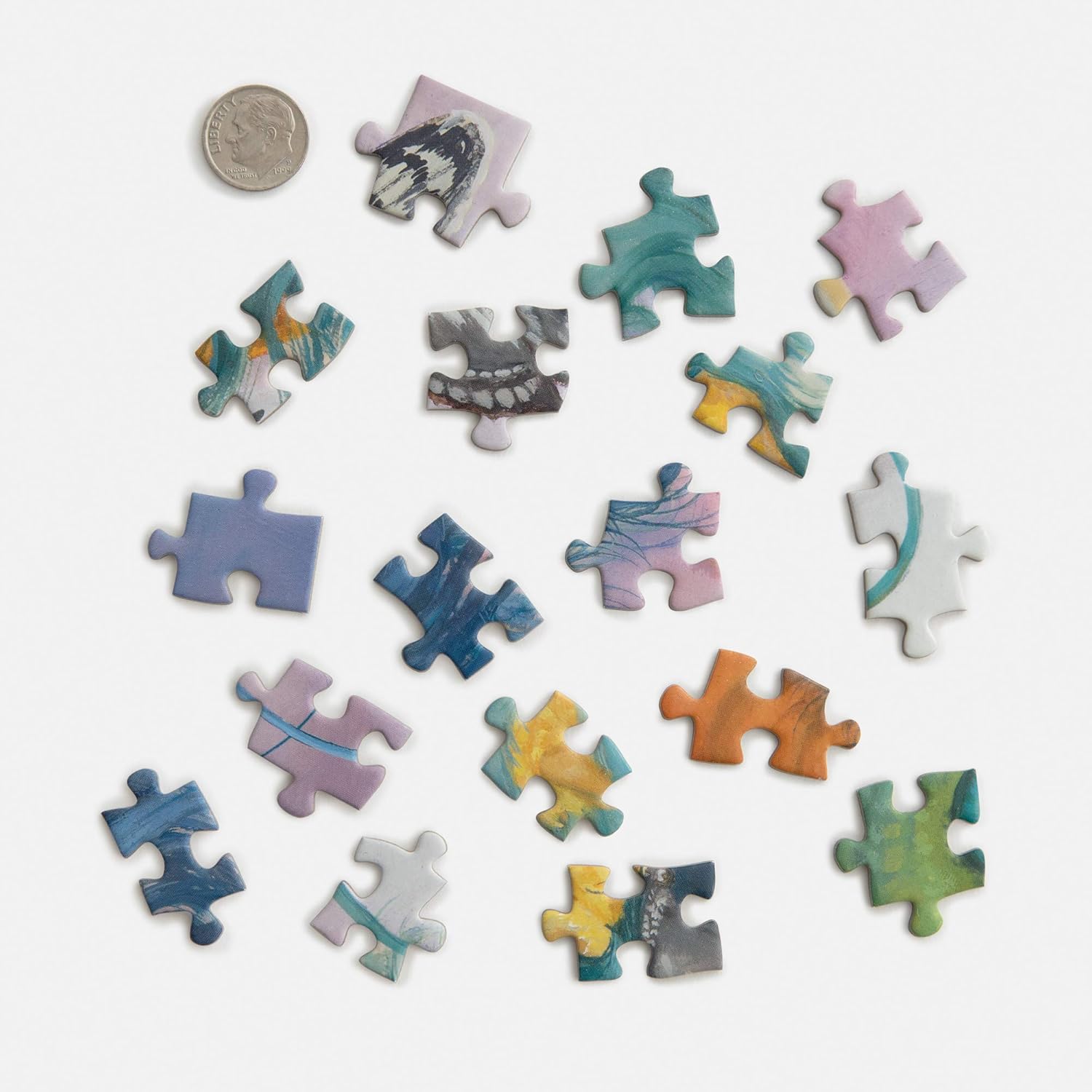 Colorful puzzle pieces on a white background with a coin for scale.