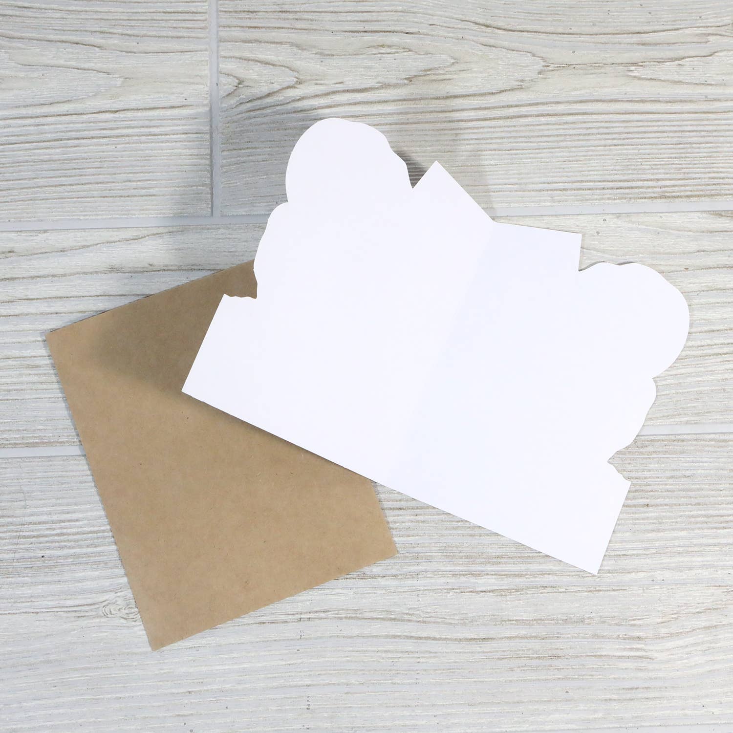 White paper cutout of a card on a wooden surface