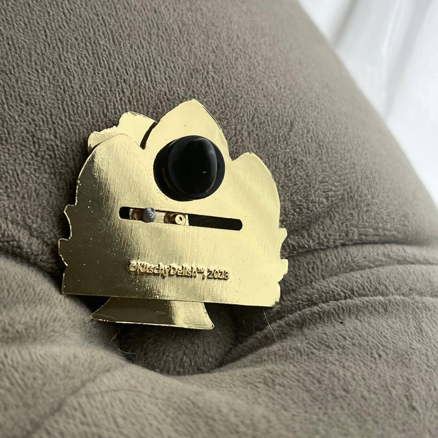 Back part of a moving enamel pin in gold