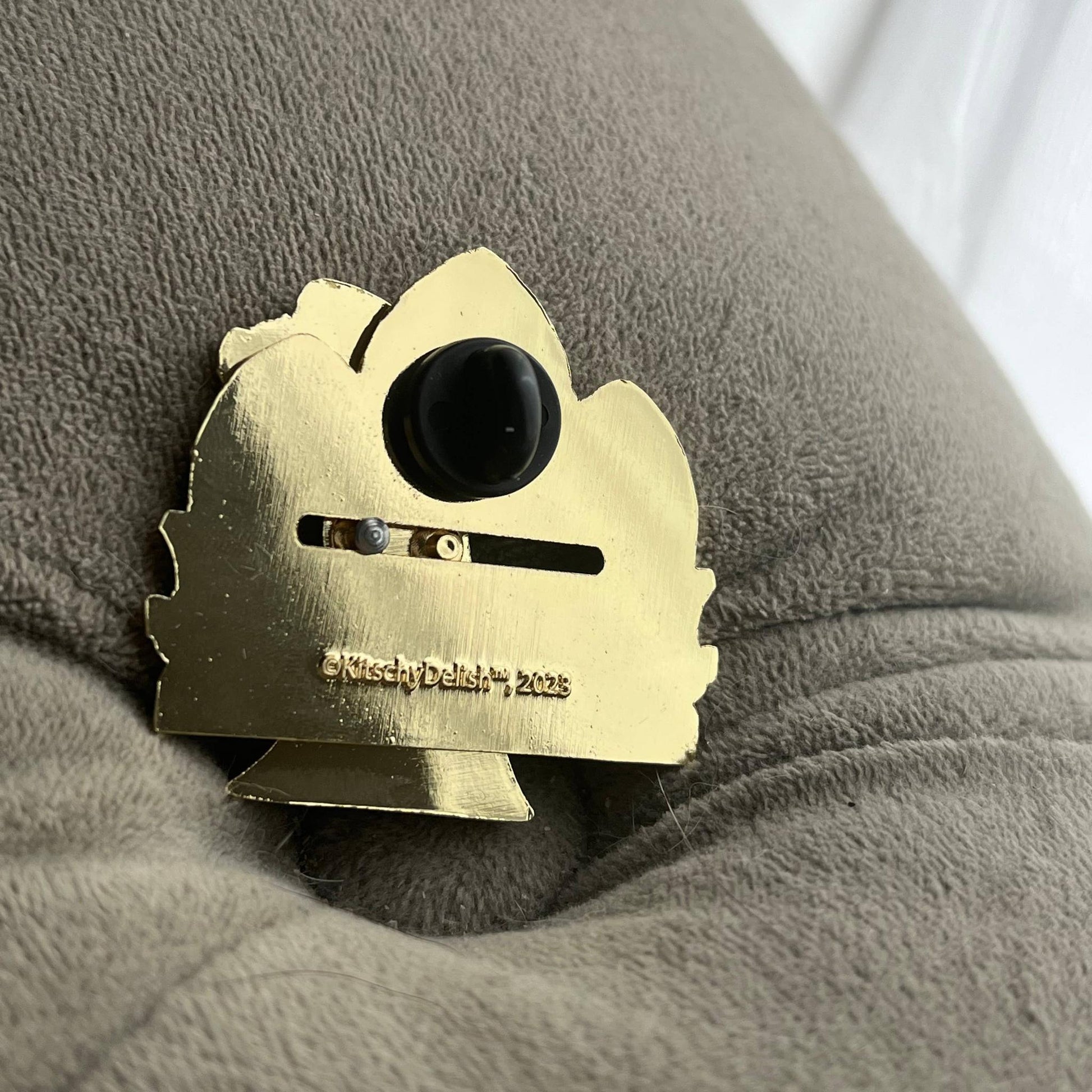 Back part of a moving enamel pin in gold